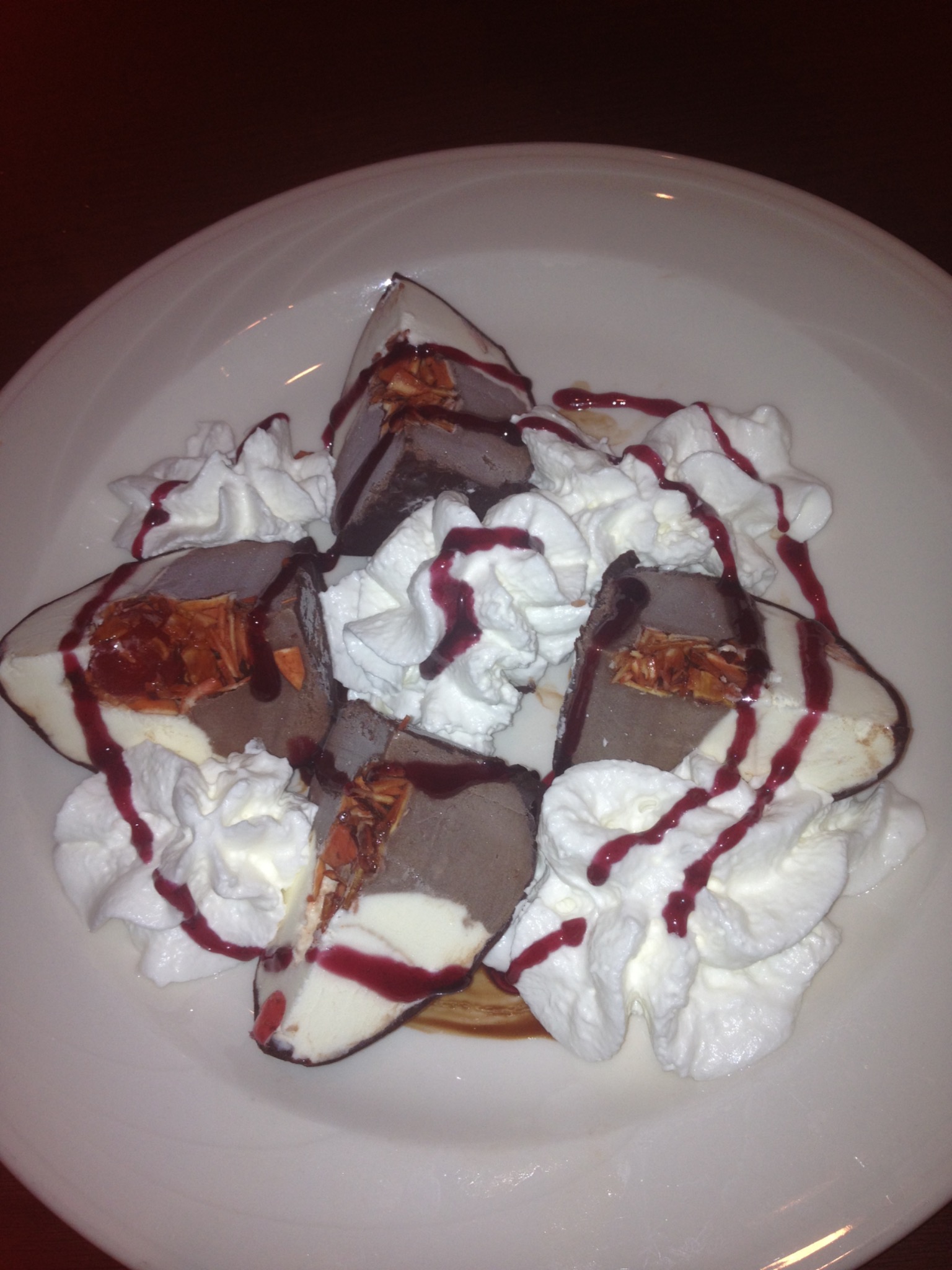 Tartufo dessert with whipped cream and berry drizzle