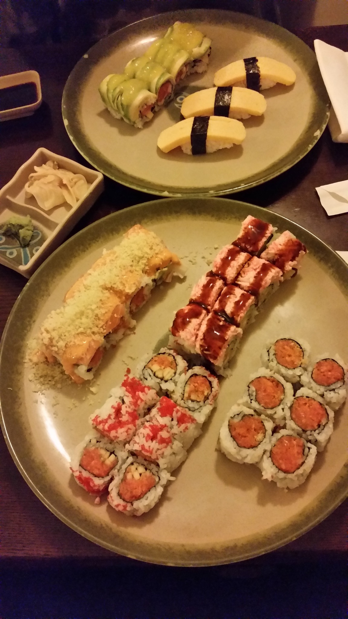 Sushi rolls and tamago nigiri arranged on green plates